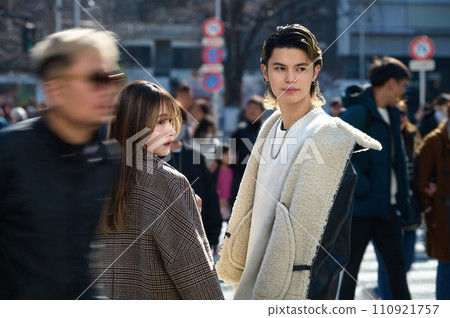 A young couple standing with the city of Shibuya in the background A young couple standing with the city of Shibuya in the background 110921757