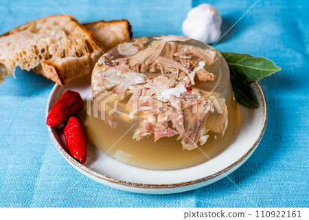 Jelly with meat, beef aspic, traditional dish. portion on plate. Bread and chili. Jelly with meat, beef aspic, traditional dish. portion on plate. Bread and chili. 110922161