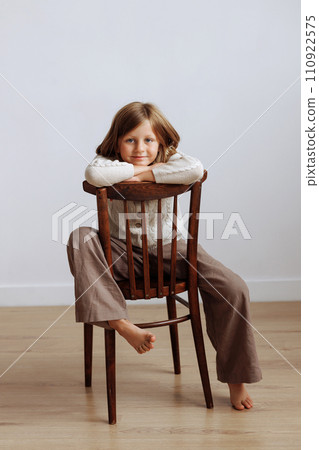 A child in casual clothes jumping on a bed with a pillow in his hands A child in casual clothes jumping on a bed with a pillow in his hands 110922575