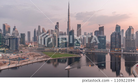 Aerial view to Dubai Business Bay and Downtown with the various skyscrapers and towers night to day timelapse 110922894