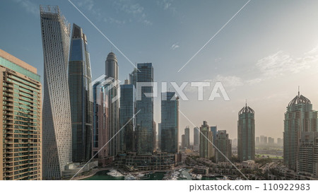 Dubai marina tallest skyscrapers and yachts in harbor aerial night to day timelapse. 110922983