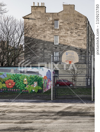 Basketball backboard with the orange hoop metal ring at outdoor basketball courts in the park. Basketball backboard with the orange hoop metal ring at outdoor basketball courts in the park. 110923780