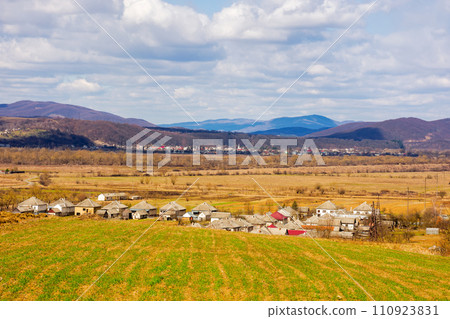 village in the wide valley in spring. mountainous rural landscape of ukraine. agricultural fields on the hills. clouds on the sky. wonderful countryside scenery of transcarpathia 110923831