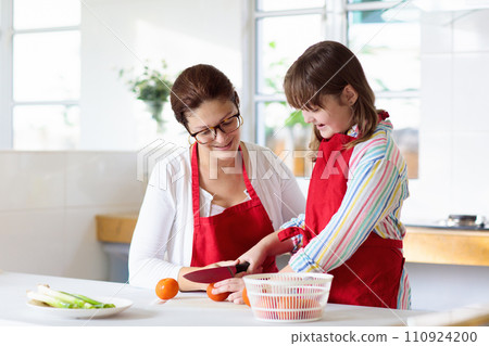 Mother and child cook. Mom and kid in kitchen Mother and child cook. Mom and kid in kitchen 110924200