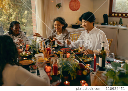 Group of smiling friends enjoying in conversation and drinking wine during Christmas party at home Group of smiling friends enjoying in conversation and drinking wine during Christmas party at home 110924451