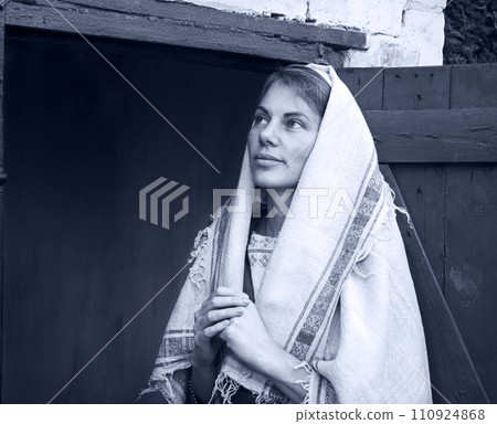 A woman in ancient clothes is standing at the door 110924868