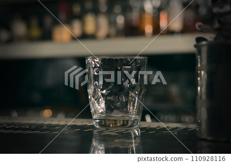 Glass of whiskey and ice on bar counter in pub or restaurant. 110928116
