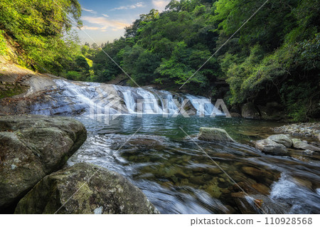 Waterfall in a peaceful green forest 110928568