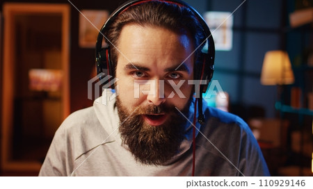 Content creator greeting audience, filming tutorial on how to defeat enemies in multiplayer game, zoom in shot. Close up on pro gamer playing videogame, teaching viewers esports strategies 110929146