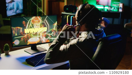 Exulting gamer jumping from joy after winning level in first person shooter, killing all enemies. Euphoric player loudly manifesting himself after being victorious in videogame 110929180