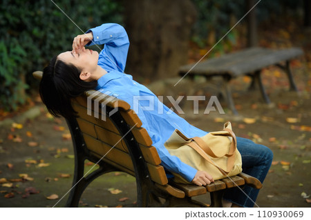 一個憂心忡忡的女人坐在長凳上 一個憂心忡忡的女人坐在長凳上 110930069