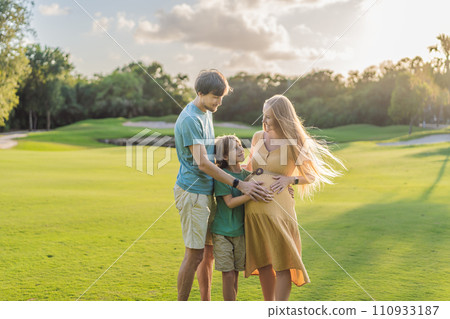 Joyful family time as a pregnant woman, her husband, and son share quality moments outdoors, embracing the beauty of nature and creating cherished memories together 110933187