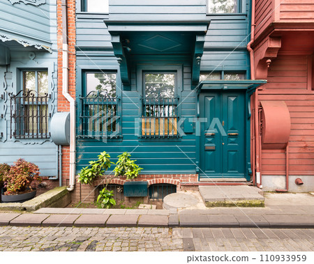Green house with wooden decorated door and ornate wrought iron windows, Kuzguncuk Istanbul, Turkey 110933959
