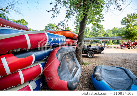 Row of inflatable rafts at the beginning of a float trip on a river. Row of inflatable rafts at the beginning of a float trip on a river. 110934102