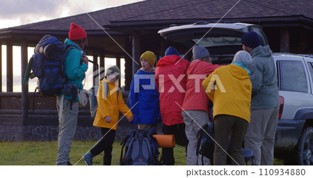 Diverse group of tourists arrive to rental house in forest on car Diverse group of tourists arrive to rental house in forest on car 110934880