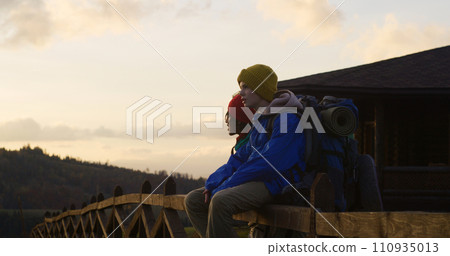 Two teenage boys look at sunset and mountain landscapes after hike Two teenage boys look at sunset and mountain landscapes after hike 110935013