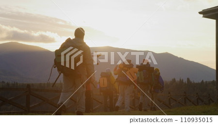 Hikers with backpacks and trekking poles go hiking in mountains Hikers with backpacks and trekking poles go hiking in mountains 110935015