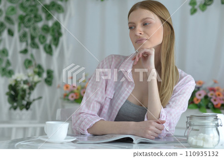 Portrait of beautiful woman drinking tea and reading magazine 110935132