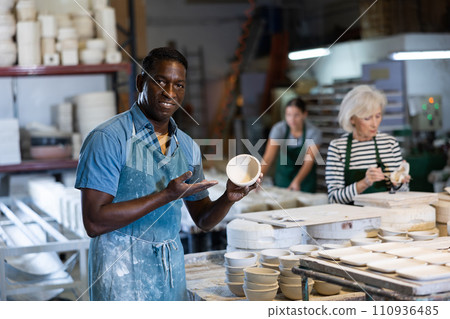 African american artisan having ceramics in hands and standing in workshop 110936485