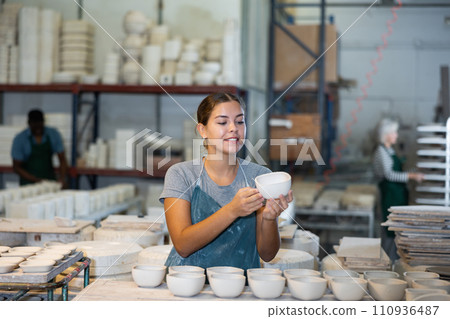 Female sculptor having ceramics in hands and standing in workroom Female sculptor having ceramics in hands and standing in workroom 110936487