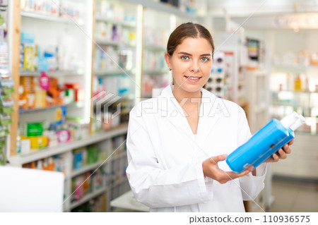 Pharmacist demonstrating haircare product 110936575