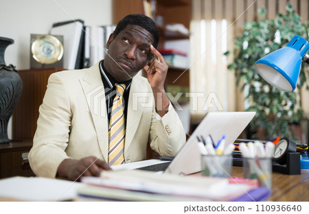 Focused african american businessman works in the office at an computer Focused african american businessman works in the office at an computer 110936640