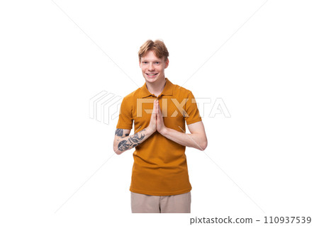 young handsome red-haired man dressed in a yellow t-shirt on a white background young handsome red-haired man dressed in a yellow t-shirt on a white background 110937539