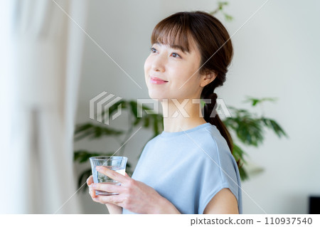 Middle woman with a cup in the living room Middle woman with a cup in the living room 110937540