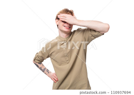 young european slender man with red short hair and a tattoo on his arm on a studio background with young european slender man with red short hair and a tattoo on his arm on a studio background with 110937694