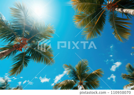 Blue sky with clouds and a view of palm trees from below. Tropical beach and summer background, travel and vacation concept Blue sky with clouds and a view of palm trees from below. Tropical beach and summer background, travel and vacation concept 110938070