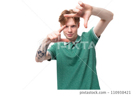 a young european man with red hair and a stylish hairstyle is dressed in a green summer t-shirt 110938421