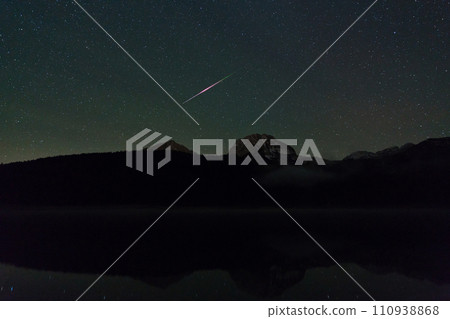 meteor in the night sky over a Black lake in the Durmitor National Park 110938868
