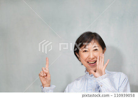 穿著褶邊襯衫並指著的中年婦女 110939058