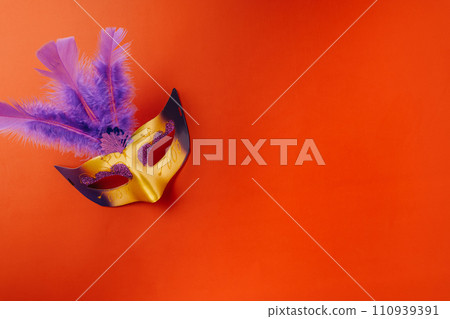 Happy Purim carnival. Carnival mask for Mardi Gras celebration isolated on red background with copy space, jewish holiday, Purim in Hebrew holiday carnival ball, Venetian mask, masquerade accessory 110939391