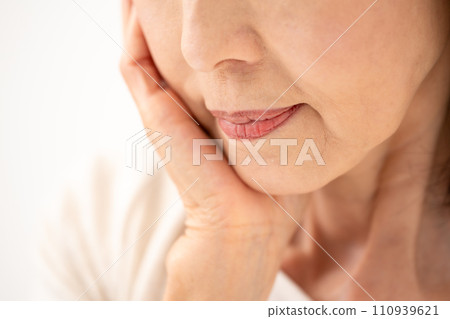 一個 60 多歲的女人摸著臉頰 110939621