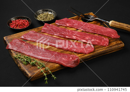 Raw beef strips on black background 110941745