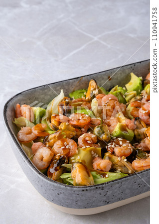 Closeup view of bowl with salad with shrimp, mussels and avocado Closeup view of bowl with salad with shrimp, mussels and avocado 110941758