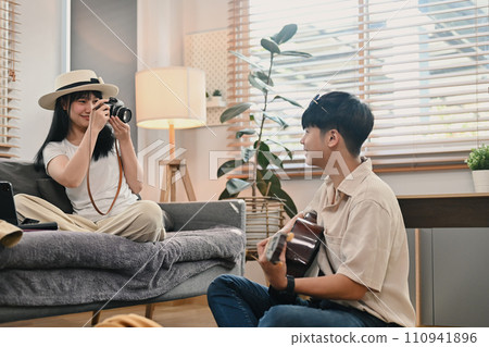 Young asian couple packing cloth and stuff for their holiday travel trip together in living room. 110941896