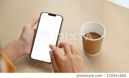 Woman hands holding mobile phone with blank screen for advertising text message. Closeup view Woman hands holding mobile phone with blank screen for advertising text message. Closeup view 110941898