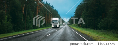 Truck Tractor Unit, Prime Mover, Traction Unit In Motion On Road, Freeway. Asphalt Motorway Highway Against Background Of Forest Landscape. Business Transportation And Trucking Industry 110943729