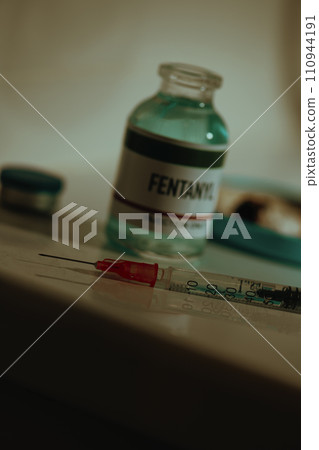 open vial of fentanyl and syringe on sordid toilet 110944191