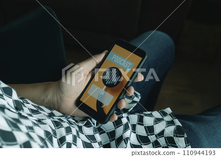 man listening a mock podcast in his smartphone 110944193