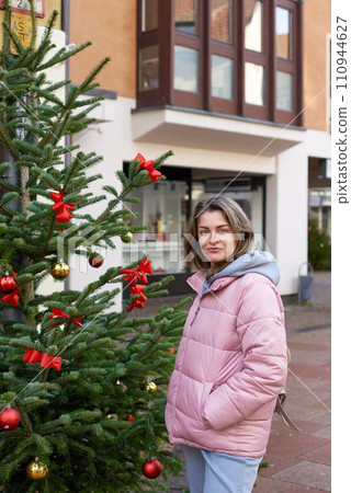 European Elegance: Christmas in Bietigheim-Bissingen. A beautiful girl stands on the street of the old European town of Bietigheim-Bissingen in Germany on Christmas Eve. City streets are decorated 110944627