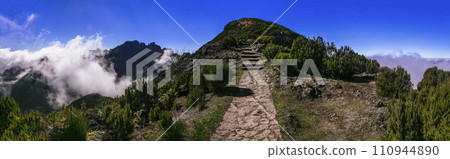 Hiking activity in Madeira island rocky mountains. Trail for Pico Ruivo highest point passing in the clouds Hiking activity in Madeira island rocky mountains. Trail for Pico Ruivo highest point passing in the clouds 110944890