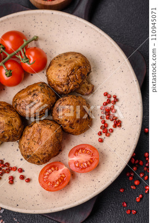 Delicious juicy whole champignons baked on the grill with salt and spices 110945071