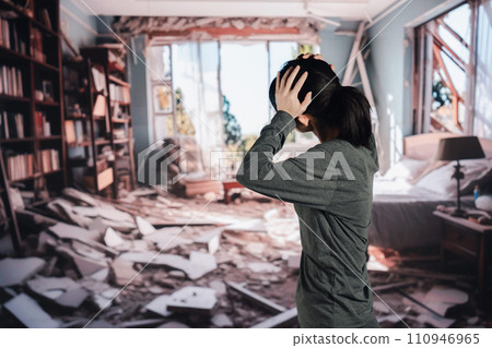 A woman is at a loss after her house collapses due to an earthquake. 110946965