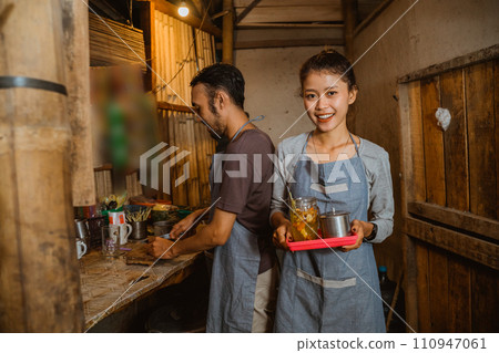 stallholder woman carrying a tray while serving traditional drinks 110947061