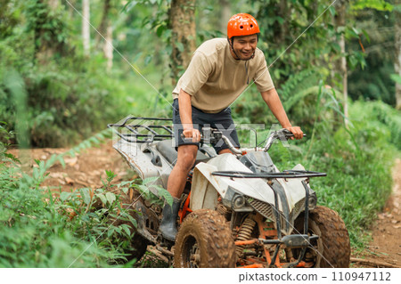 happy asian man smiling while riding the atv happy asian man smiling while riding the atv 110947112