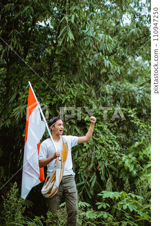 a handsome man in white t shirt standing grab the indonesian flag a handsome man in white t shirt standing grab the indonesian flag 110947250