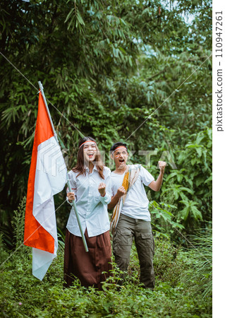 a handsome man and a beautiful woman standing together at the forest a handsome man and a beautiful woman standing together at the forest 110947261
